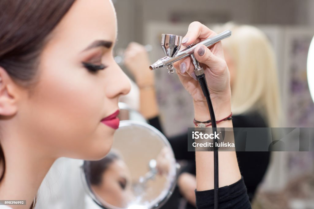 makeup artist using airbrusher.